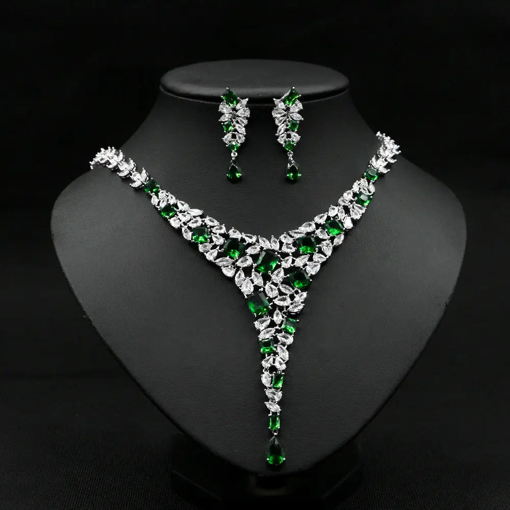 Elegant emerald and crystal leaf-patterned zircon necklace set featuring a v-neck design with sparkling clear stones and deep green gemstones as a colorful zircon necklace set.