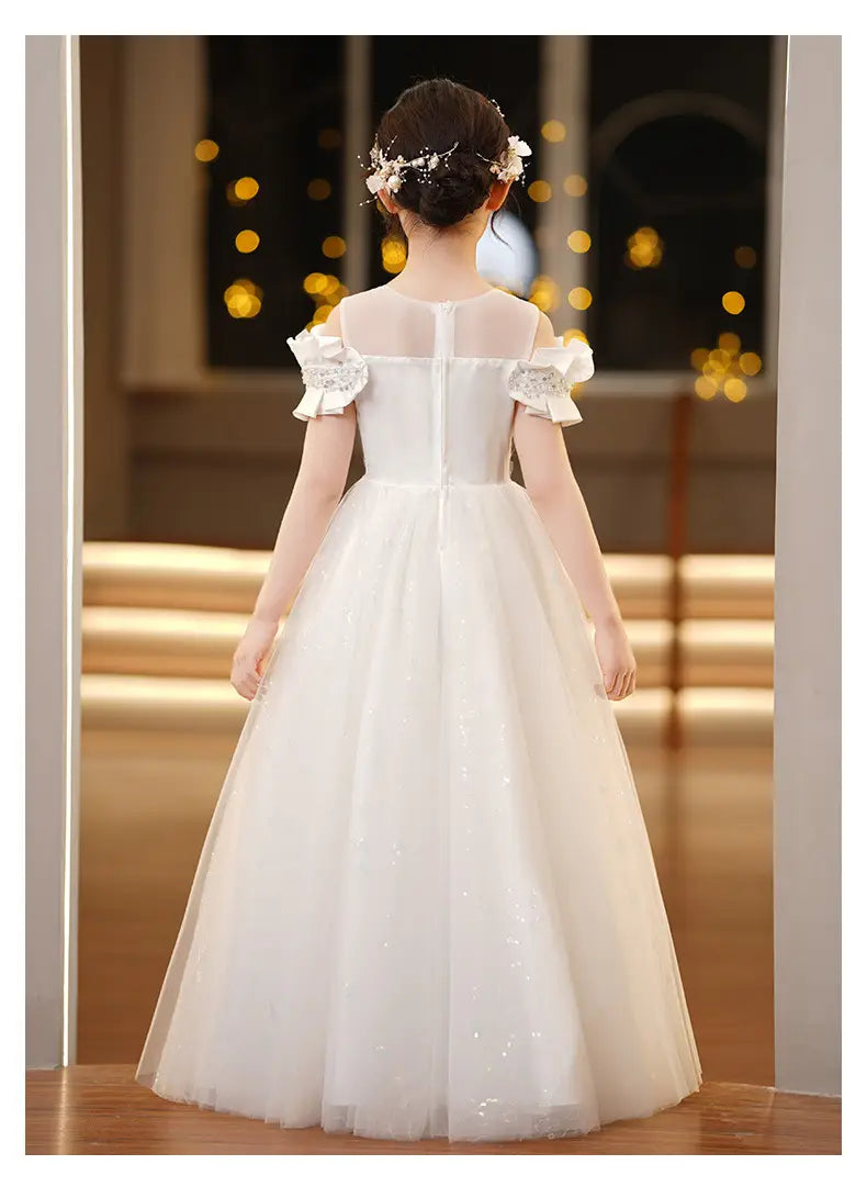 A delicate white off-the-shoulder spandex princess dress for girls featuring sheer mesh panels lace-trimmed ruffled sleeves and a flowing tulle tutu skirt.
