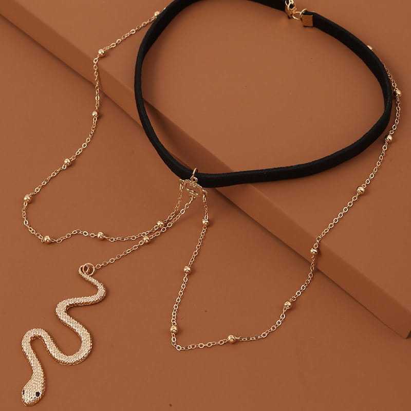 Bohemian boho gold big snake leg chain jewelry featuring a gold snake pendant necklace with a black choker strap and beaded chains.