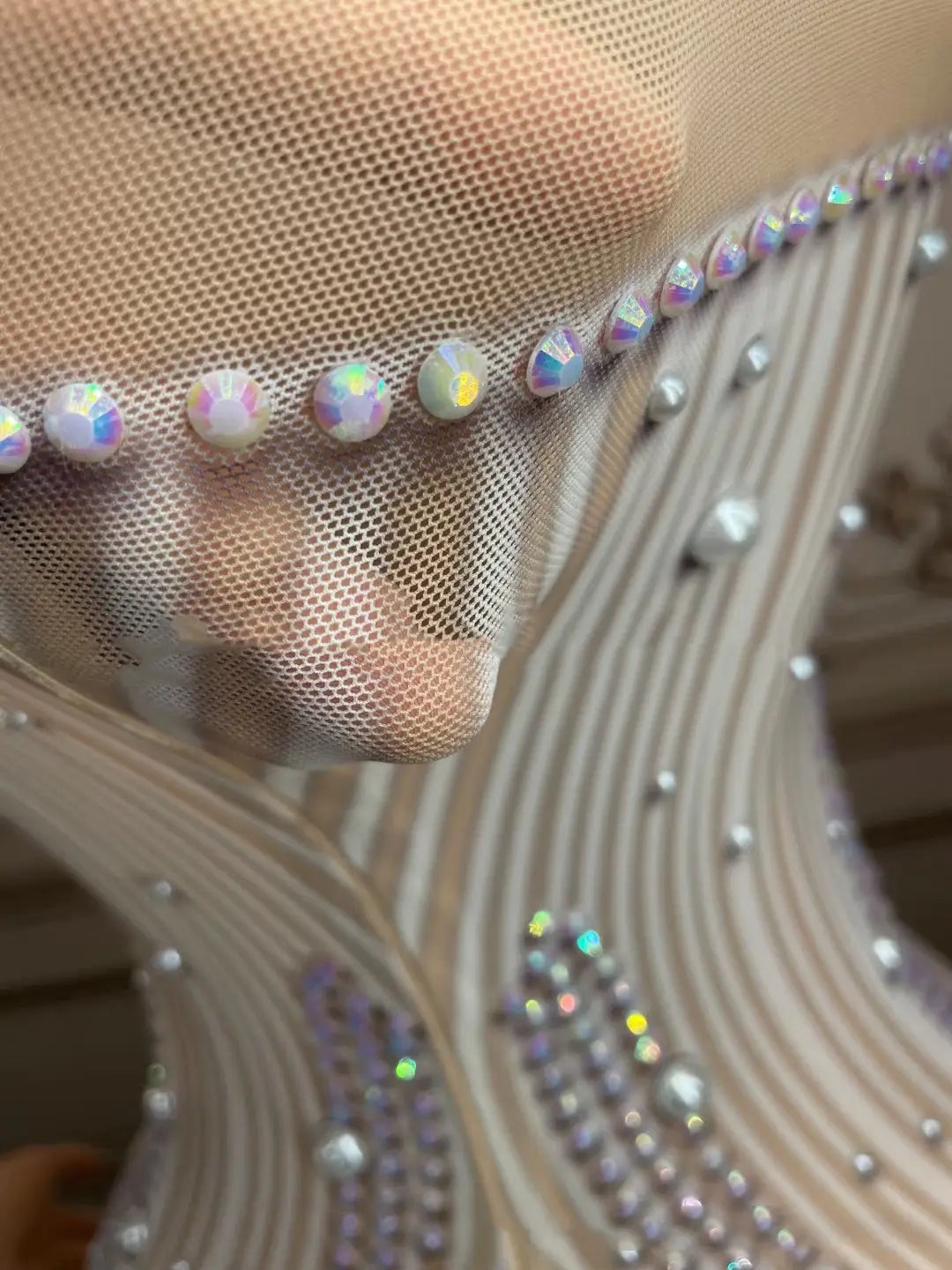 a silver feathered hips nightclub bar sleeveless long gown featuring delicate beige mesh fabric adorned with rows of iridescent and clear rhinestones.