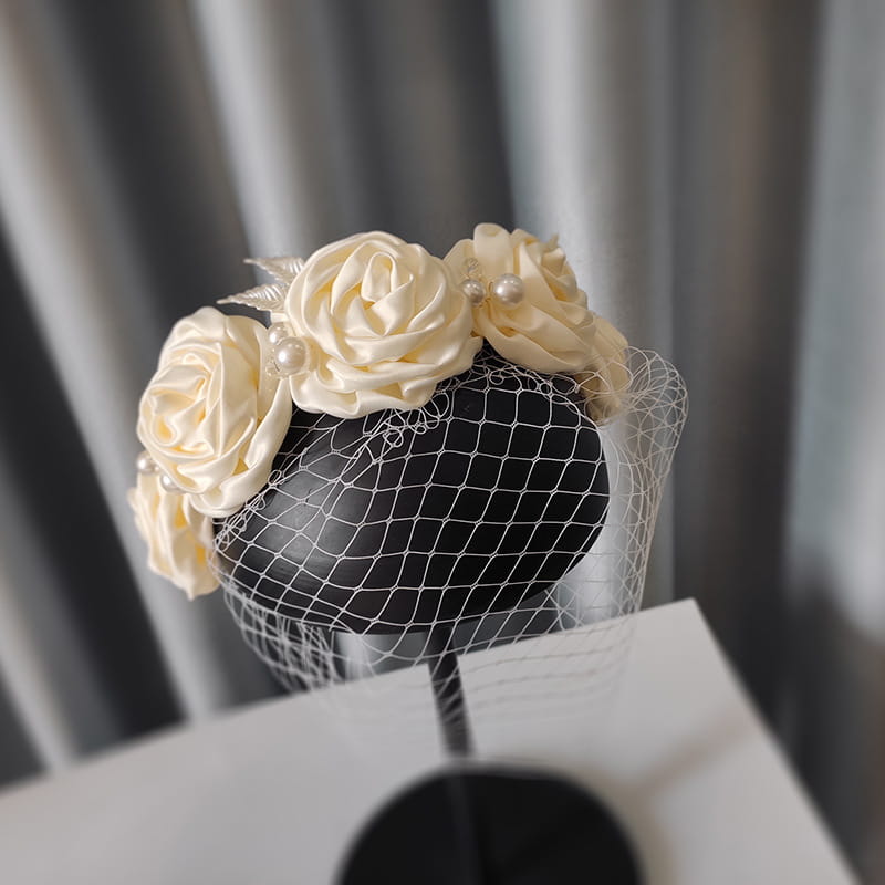 Elegant ivory satin rose hair hoop headdress adorned with delicate pearls and a fine white mesh veil for wedding dress wear.