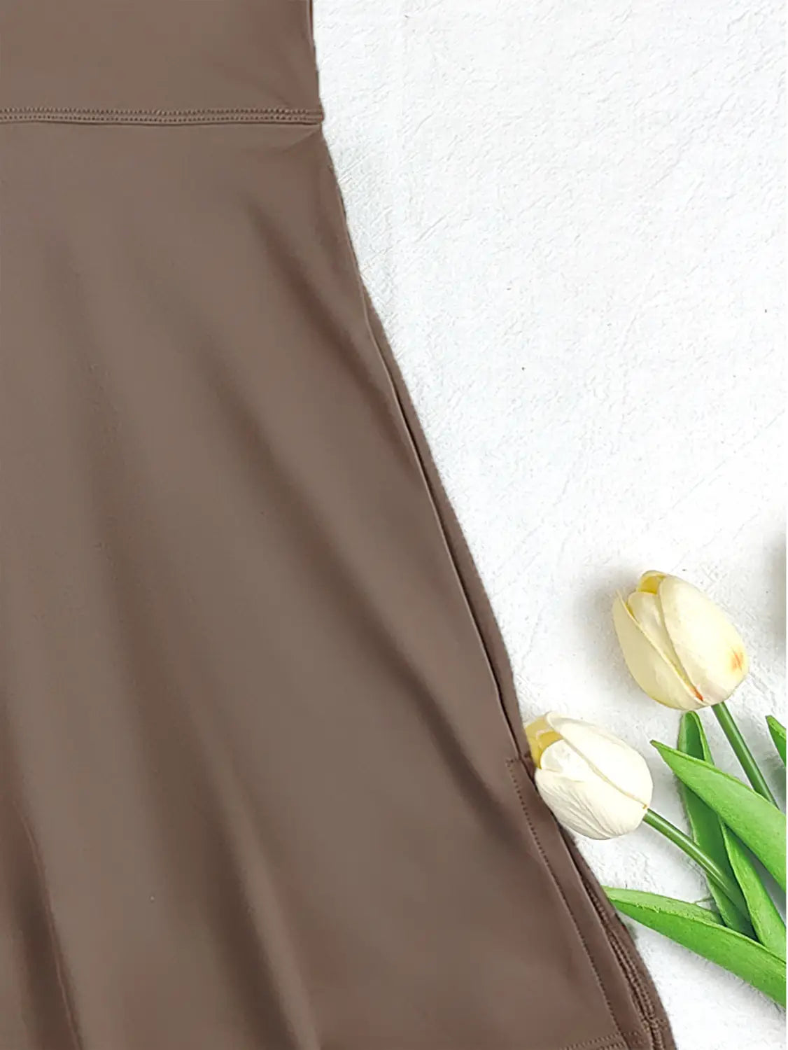 a smooth taupe-colored sleeveless side slit yoga tennis skirt sport dress with subtle sheen and fine stitching along the waistband