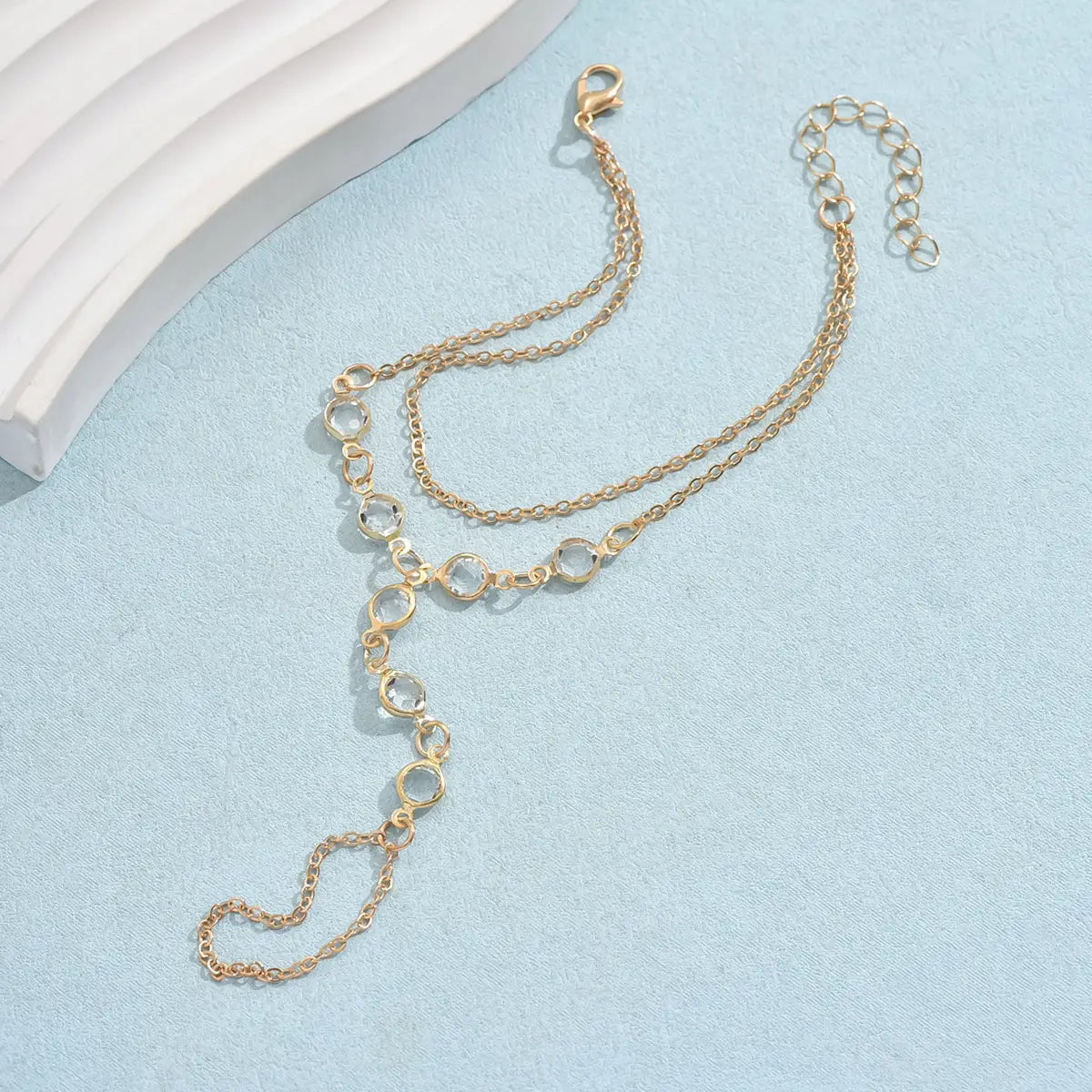 Gold-toned double-layer chain anklet with interlocking circular links and lobster clasp complementing a silver crystal fashion minimalist bracelet ring for american fashion minimalist style.