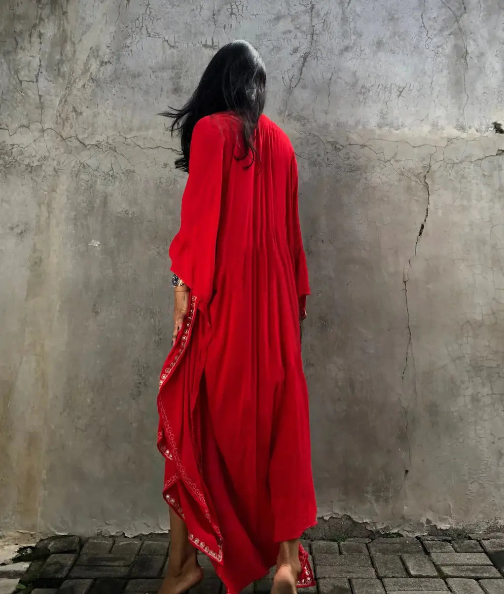a flowing vibrant red rayon embroidered holiday maxi dress with intricate white embroidery along the side seams designed for holiday sun protection