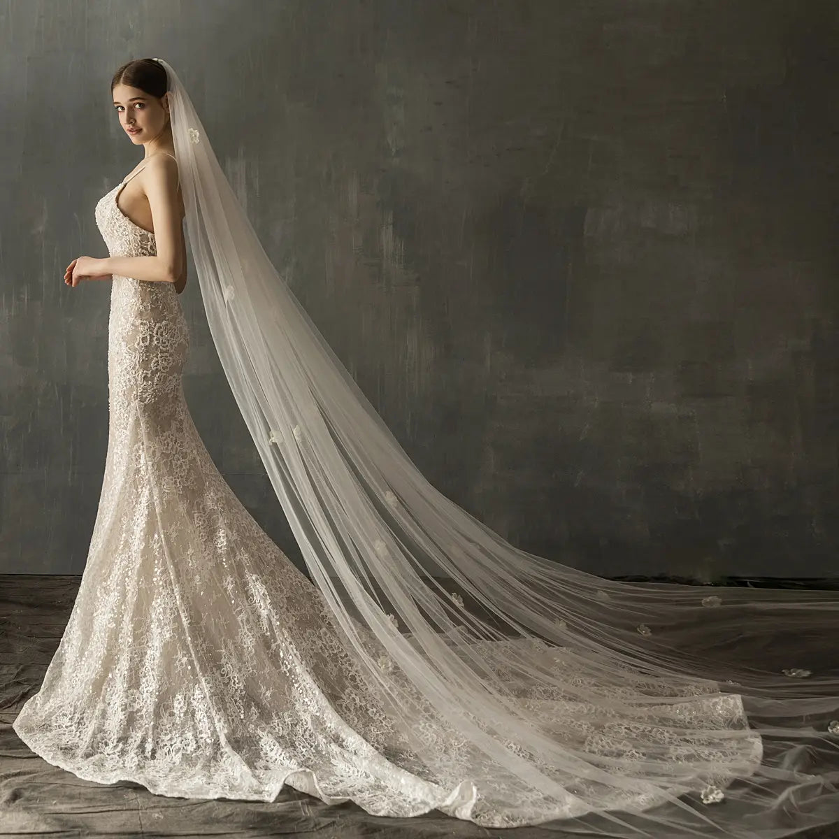 A flowing ivory lace bridal church wedding veil with delicate floral embroidery and a sheer trailing design for a church wedding pearl gown.