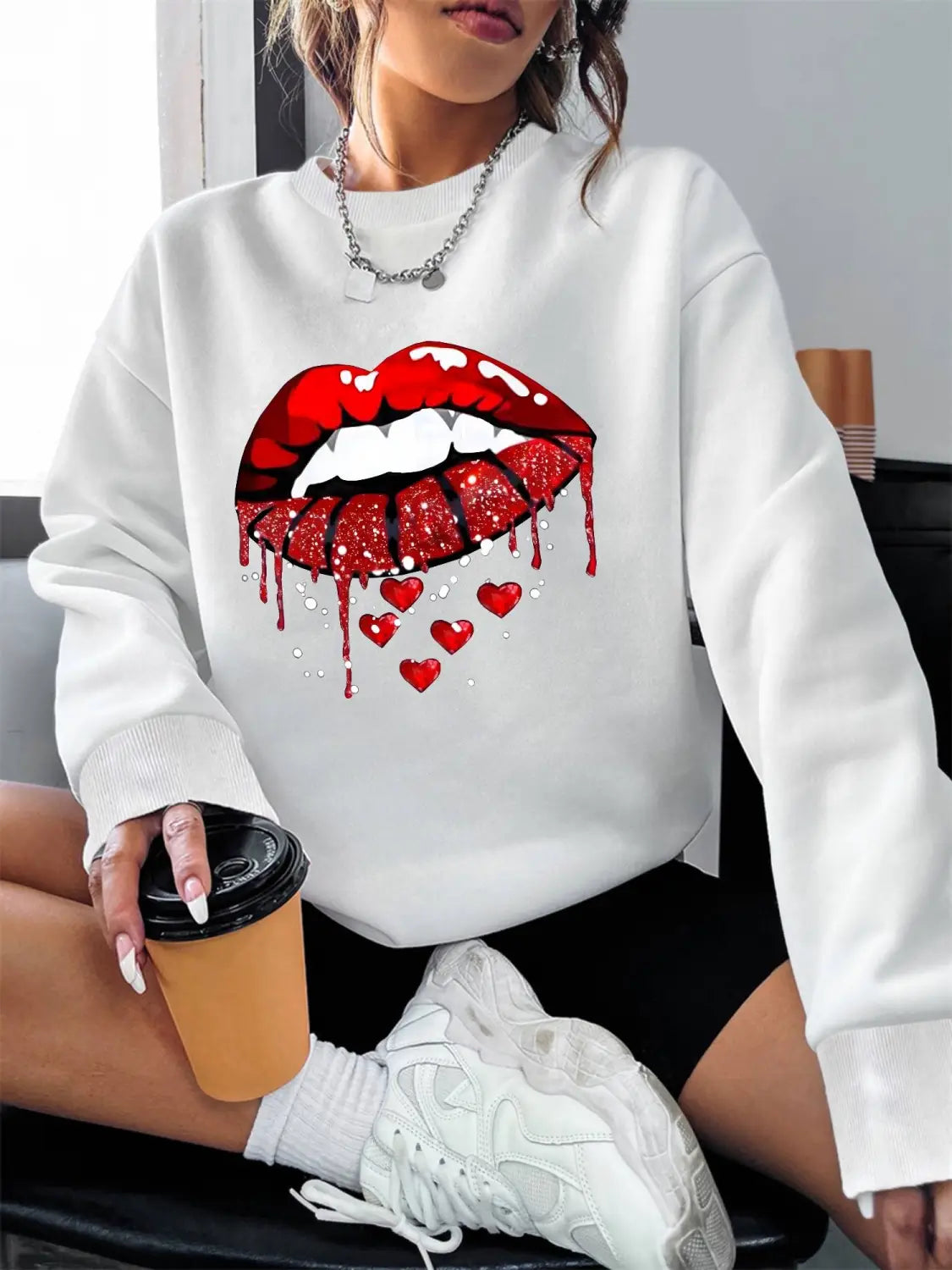white glitter lips pocketed long sleeve sweatshirt featuring a bold red glittery lips graphic with dripping effect and small hearts below on a soft white fabric.