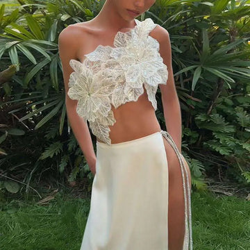 A delicate ivory lace off-the-shoulder crop top with floral appliqués paired with a backless sequined lace split skirt suit