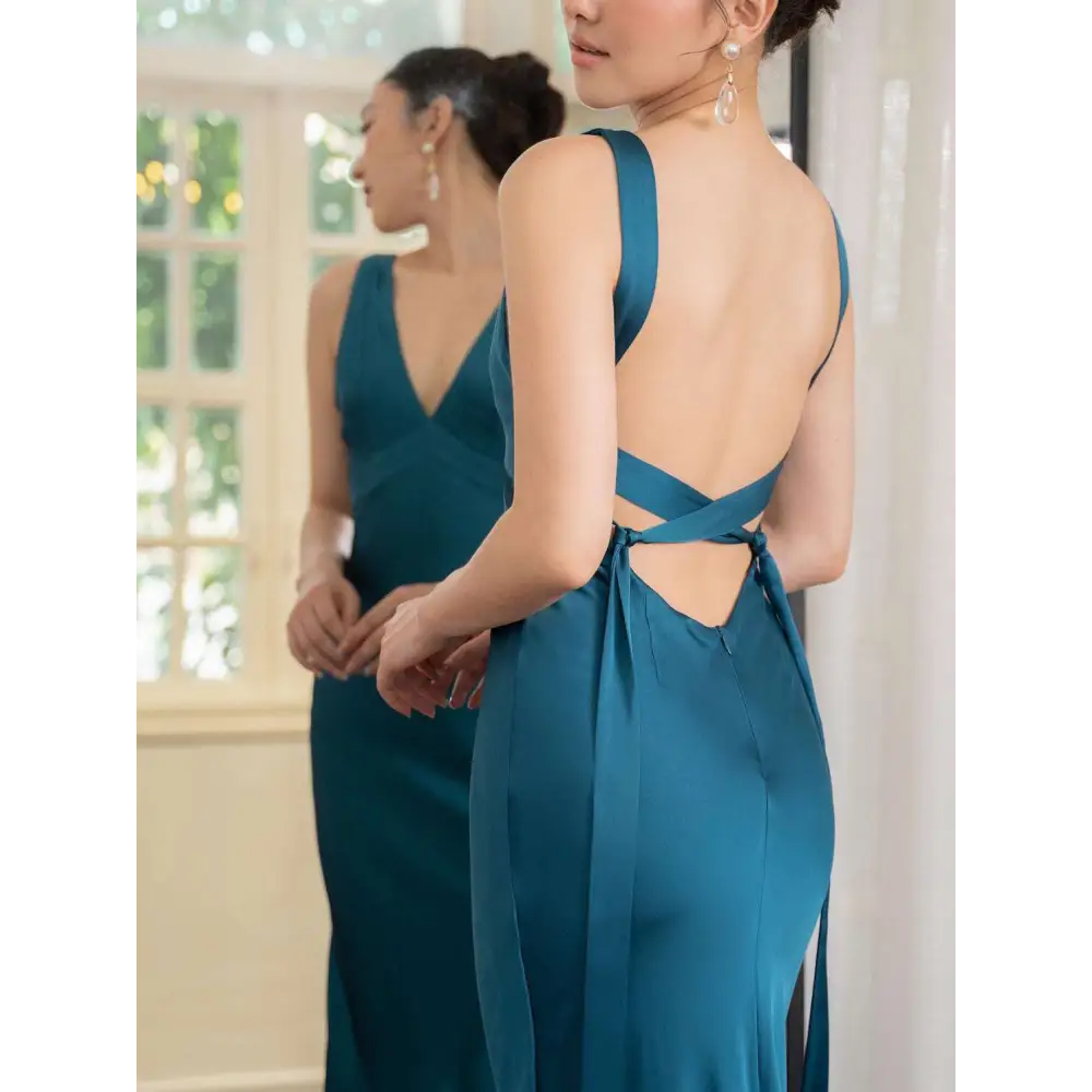 Back view of a backless strappy lake blue satin wedding dress with deep v-neckline and bow-tied straps