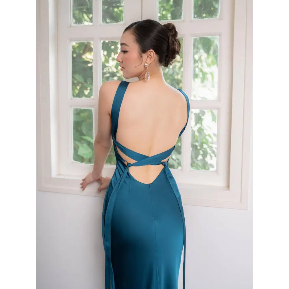 Back view of a backless strappy lake blue satin wedding dress with crisscross straps and tied details
