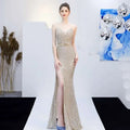 A shimmering gold sequined mermaid gown with fitted bodice, high slit, and delicate straps for banquet elegant annual events
