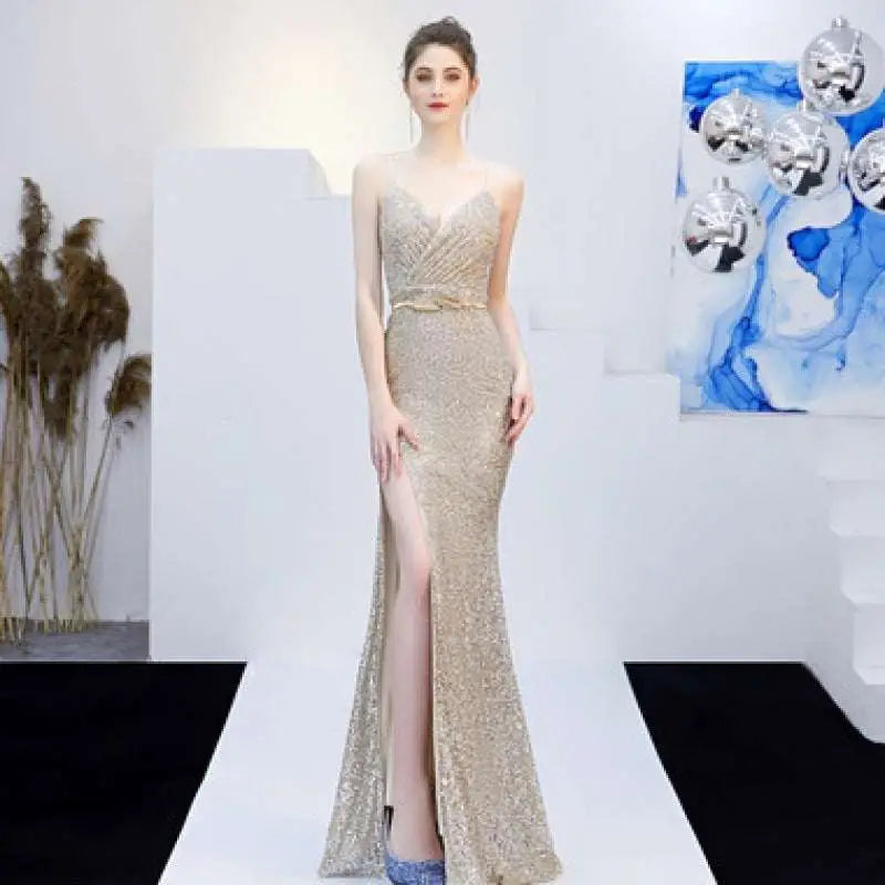 A shimmering gold sequined mermaid gown with fitted bodice, high slit, and delicate straps for banquet elegant annual events