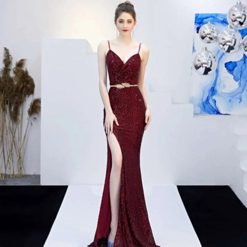 A shimmering burgundy sequined mermaid gown with a plunging v-neckline and high slit for banquet elegant annual events