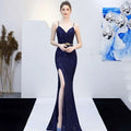 A deep navy blue sequined mermaid gown with a plunging v-neckline thin straps and a high slit for banquet elegant annual use