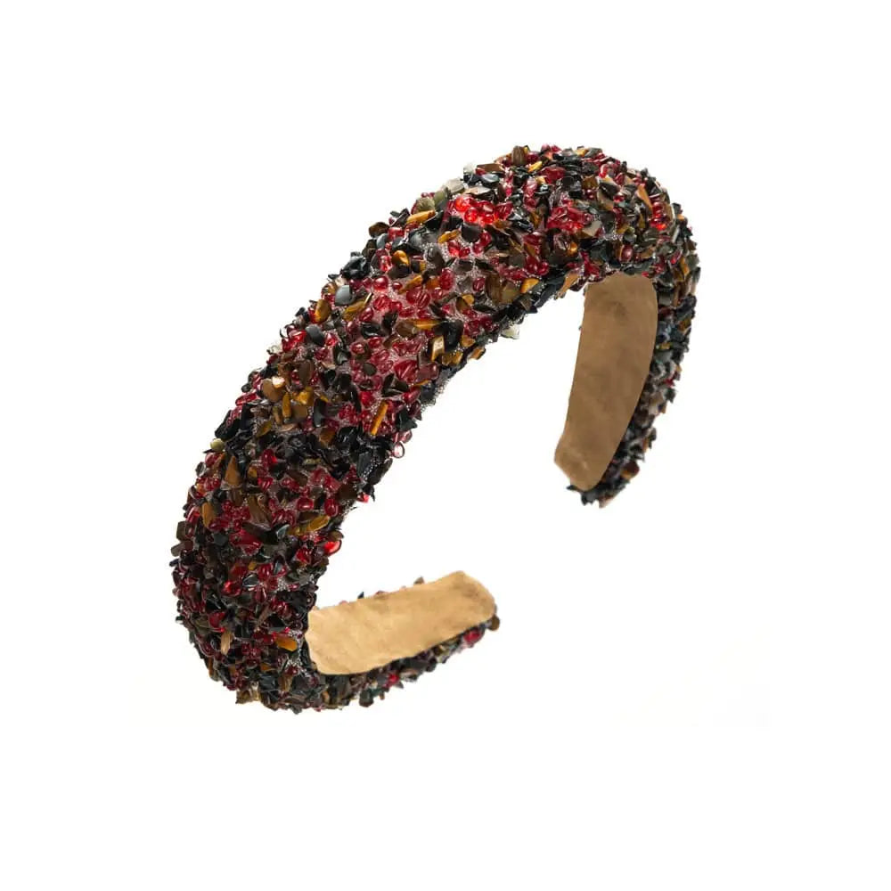 A chunky open-ended bangle design adorned with red and amber tiger’s eye stones for a baroque colorful headband sparkling gemstones look