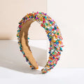 A baroque colorful headband design adorned with sparkling multicolored faceted gemstones and glittery accents