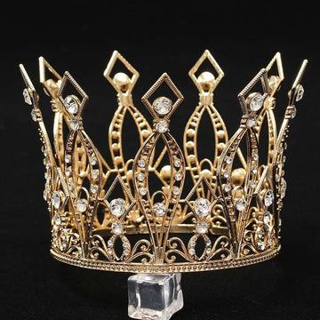 A baroque golden birthday crown cake decoration featuring a golden tiara with intricate filigree detailing and clear crystals