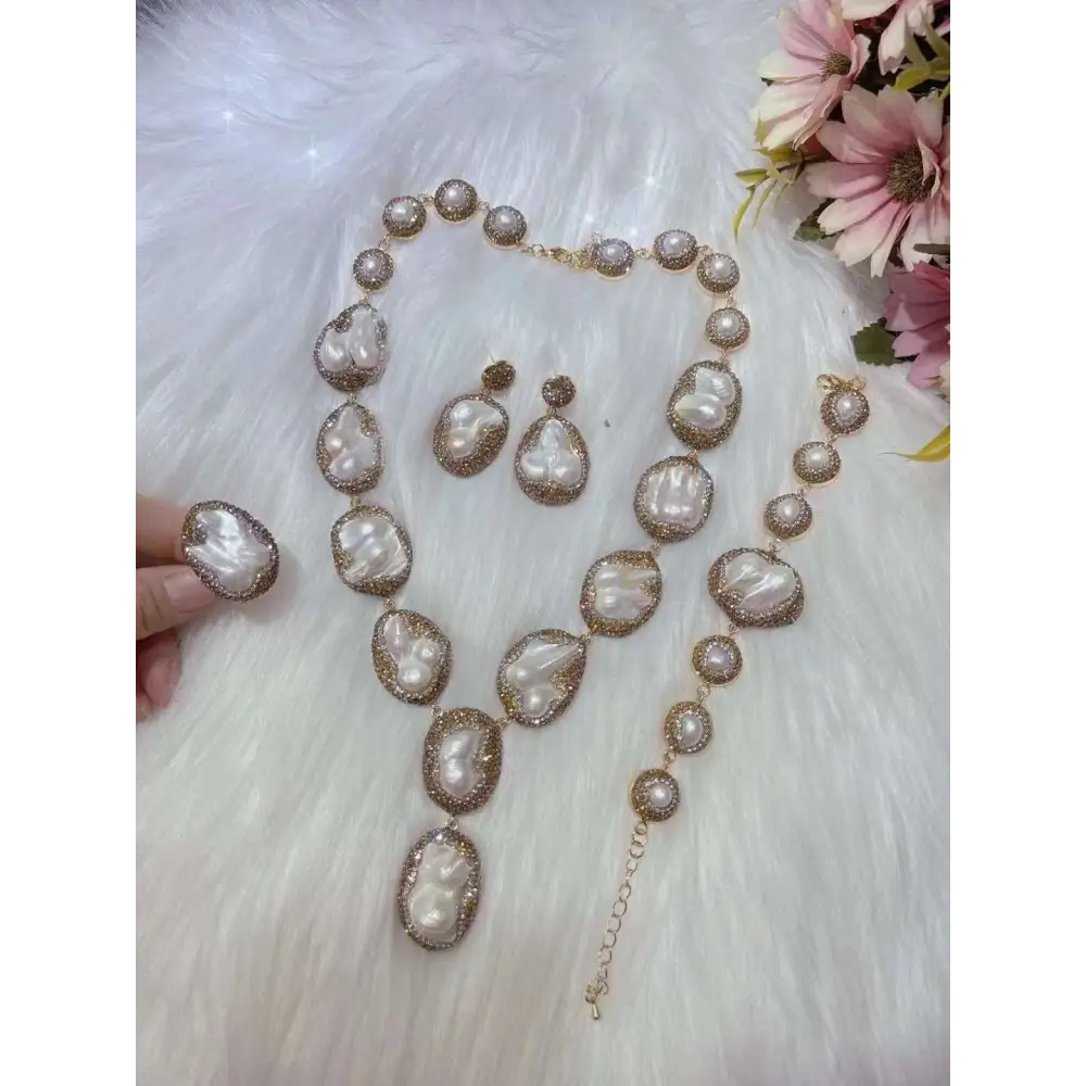 A luxurious gold-toned necklace ring suit with irregular baroque pearls and crystal accents for bride ornament use