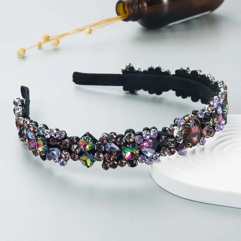 A black velvet baroque vintage court style headband featuring multicolored iridescent rhinestones in various shapes