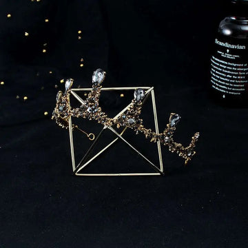 Gold-toned baroque vintage female crown adorned with clear crystals and intricate filigree as bridal jewelry