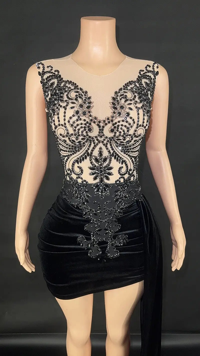 Black velvet luxury evening dress with intricate beaded lace detailing on the bodice and sheer mesh overlay featuring a side train for a summer luxury evening look.
