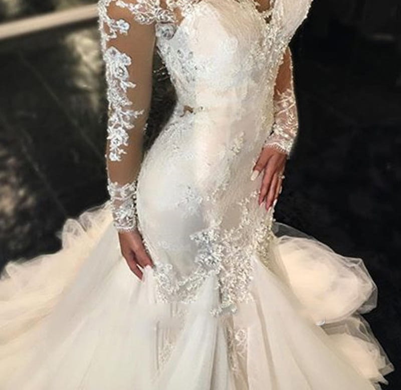 A trailing white temperament long lace wedding dress in white polyester fiber featuring a mermaid silhouette with long sheer lace sleeves and intricate floral embroidery.