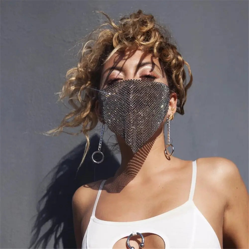 A shimmering silver mesh face mask adorned with sparkling rhinestones showcasing rhinestone metal flash design.