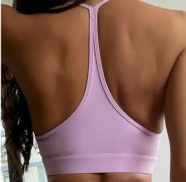Light pink seamless sports bra with a racerback design from the nude sensation waist gathering two piece yoga set by ck+wx.