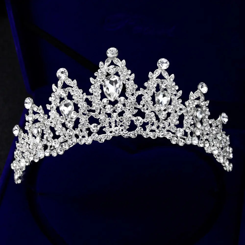 A sparkling silver bridal crown european adorned with clear crystals and teardrop-shaped stones featuring an intricate leaf-like design.