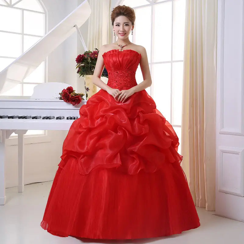 A vibrant red bustier korean princess beaded tulle wedding dress featuring a strapless fitted bodice and voluminous layered ruffles.