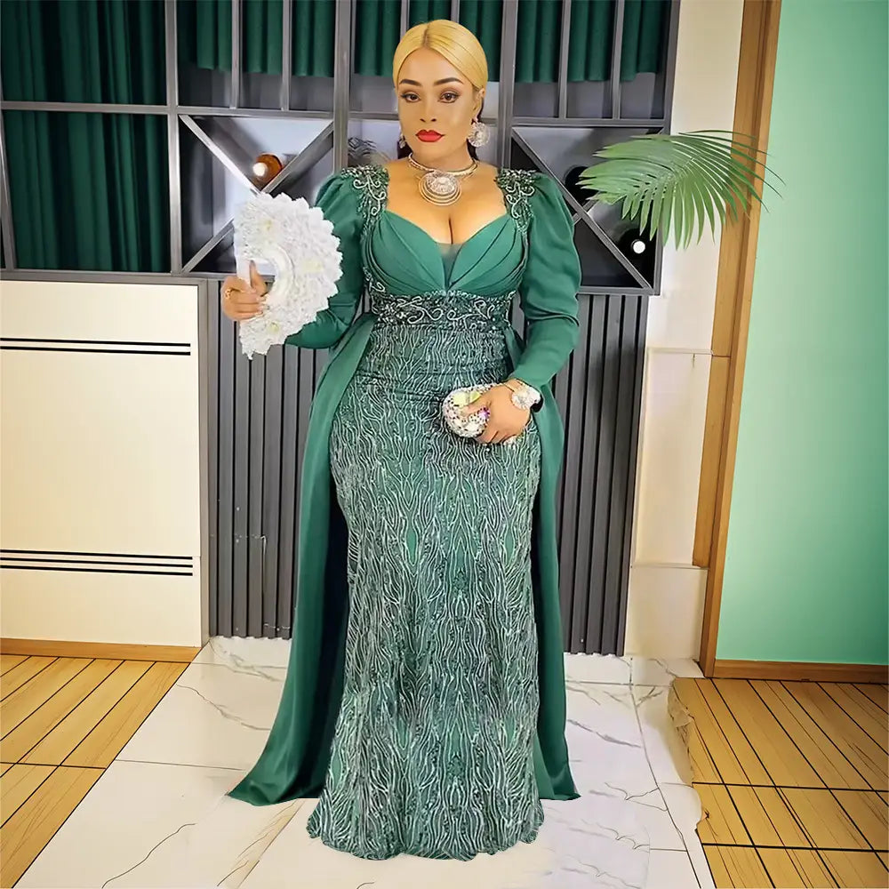 Plus size long sleeve emerald green sequined evening dress with intricate silver beading and a matching capelet for elegant occasions.