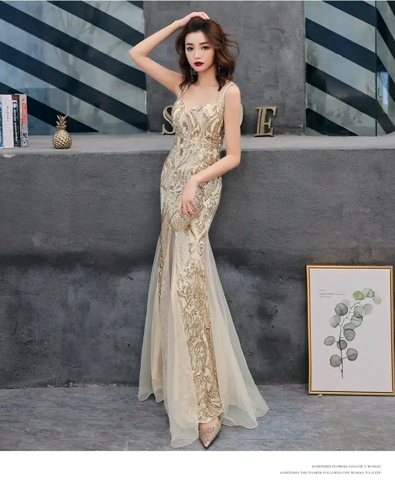 A shimmering gold-embellished black fishtail long summer sequins sling evening dress features a sheer overlay and intricate beaded detailing.
