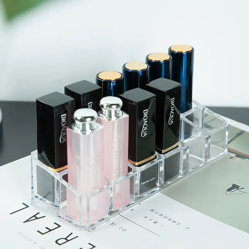 clear acrylic makeup organizer with compartments holding multiple bionaqua lipsticks in black blue and pink shades makeup organizer image