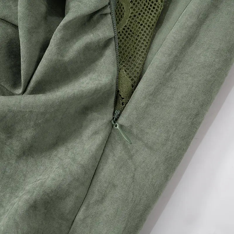olive green textured fabric with mesh lining visible at the zipper opening detail of a sage green lace backless tube featuring sling stitching ruffle and stitching ruffle hip design