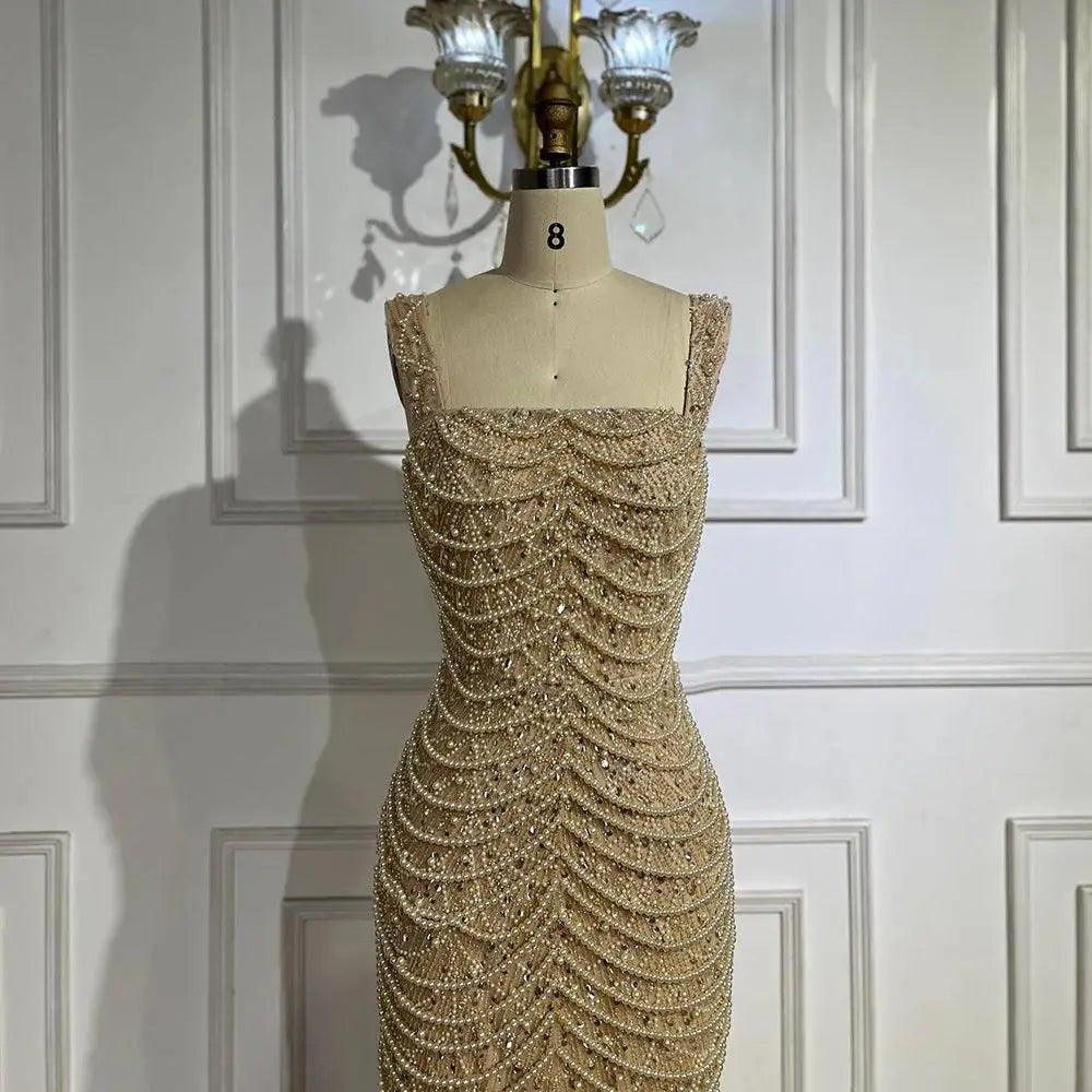 A beaded nude elegant sling luxury gown featuring intricate white and silver beads cascading down a form-fitting silhouette