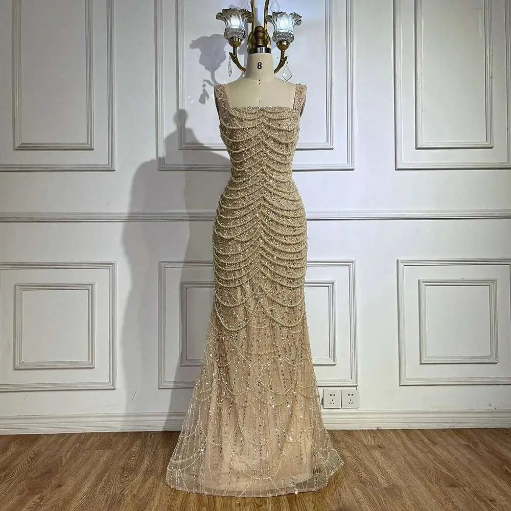 A shimmering gold beaded nude elegant sling luxury gown featuring a fitted bodice and flowing mermaid skirt