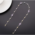 Beaded pink floral wedding hair accessories with a delicate silver chain featuring purple and clear gemstones and star charms
