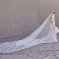 A long white yarn wedding bridal veil with delicate beaded trailing yarn edge and broadband hair comb headpiece
