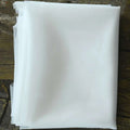 A neatly folded stack of translucent white mesh fabric for a beaded trailing yarn wedding bridal veil with broadband hair comb