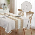 Beige and white woven x55 inch rectangle waterproof tablecloth with tassel trim for elegant dining protection