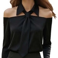 Black satin off-the-shoulder blouse with tied bow neckline featuring halter neck strap and strap lapel design