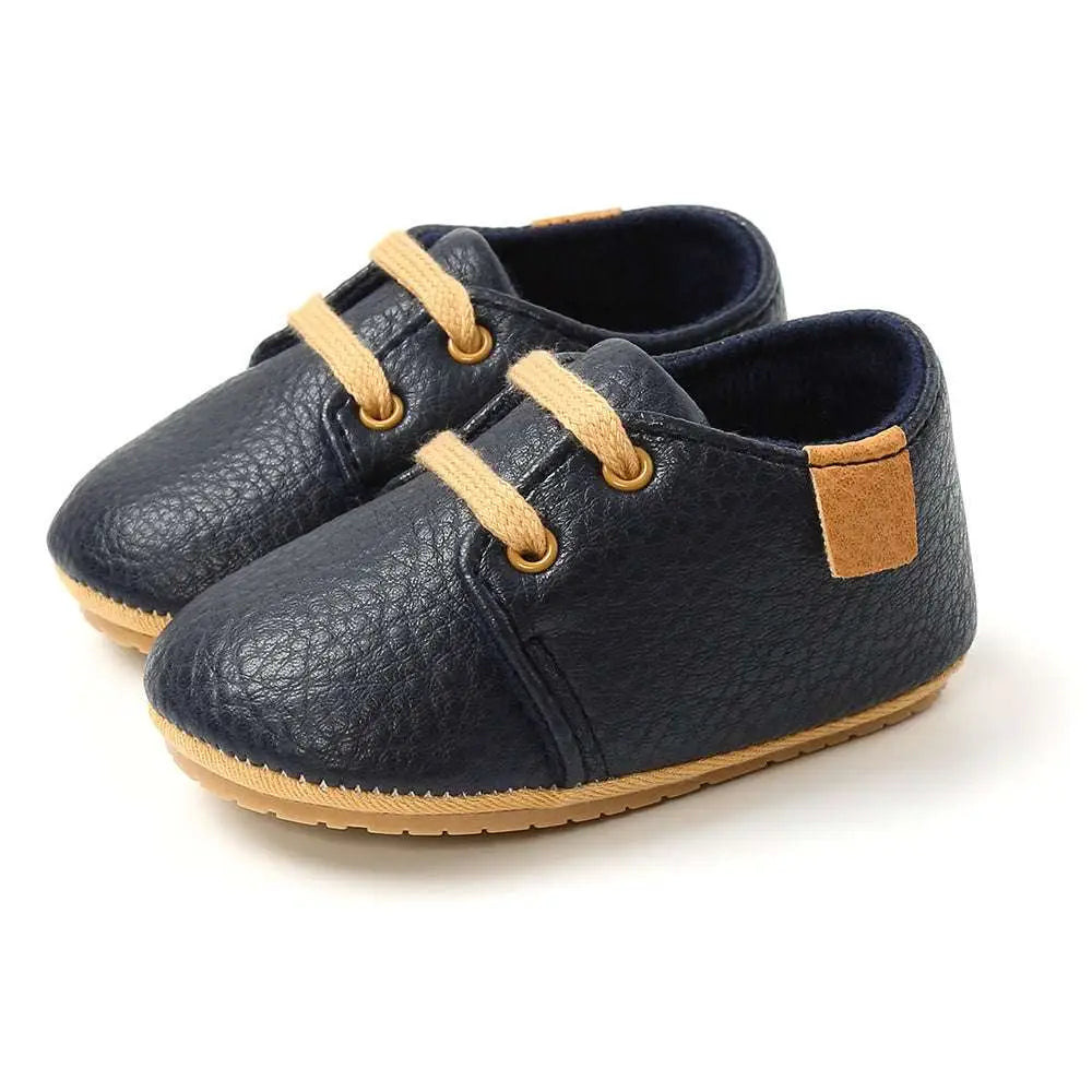Beige leather baby casual shoes featuring navy blue textured leather with tan laces and matching suede patch for women baby shoes