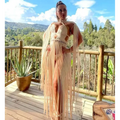 Beige macramé tassel dress featuring a cut-out bodice and long flowing fringe for creative beach travel look