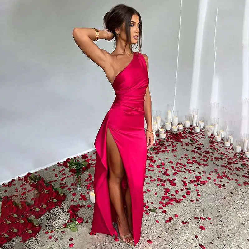A vibrant fuchsia satin one-shoulder backless slit gown with a draped bodice and high slit detail