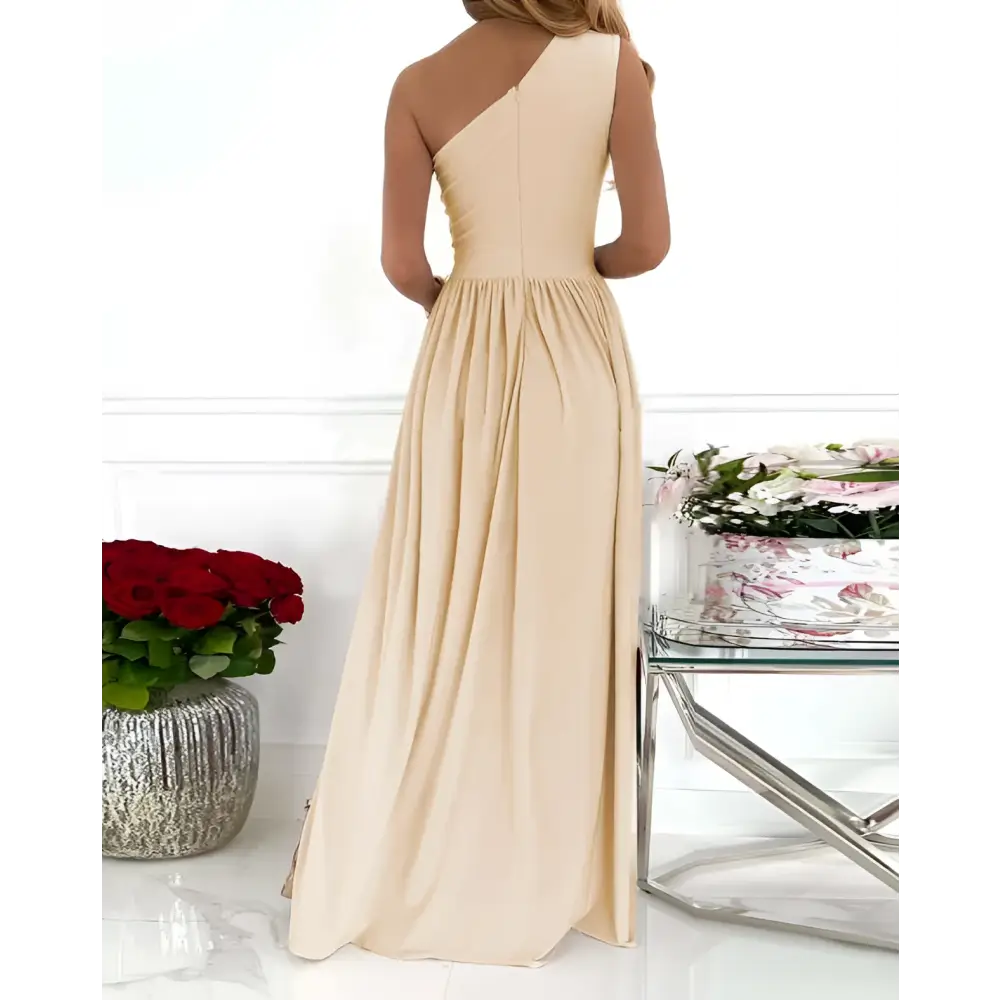 Beige one shoulder cocktail maxi dress with draped neckline and shoulder high split featuring a flowing skirt
