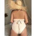 Beige ribbed one-piece swimsuit with halter neck and back tie detail shown from the back side