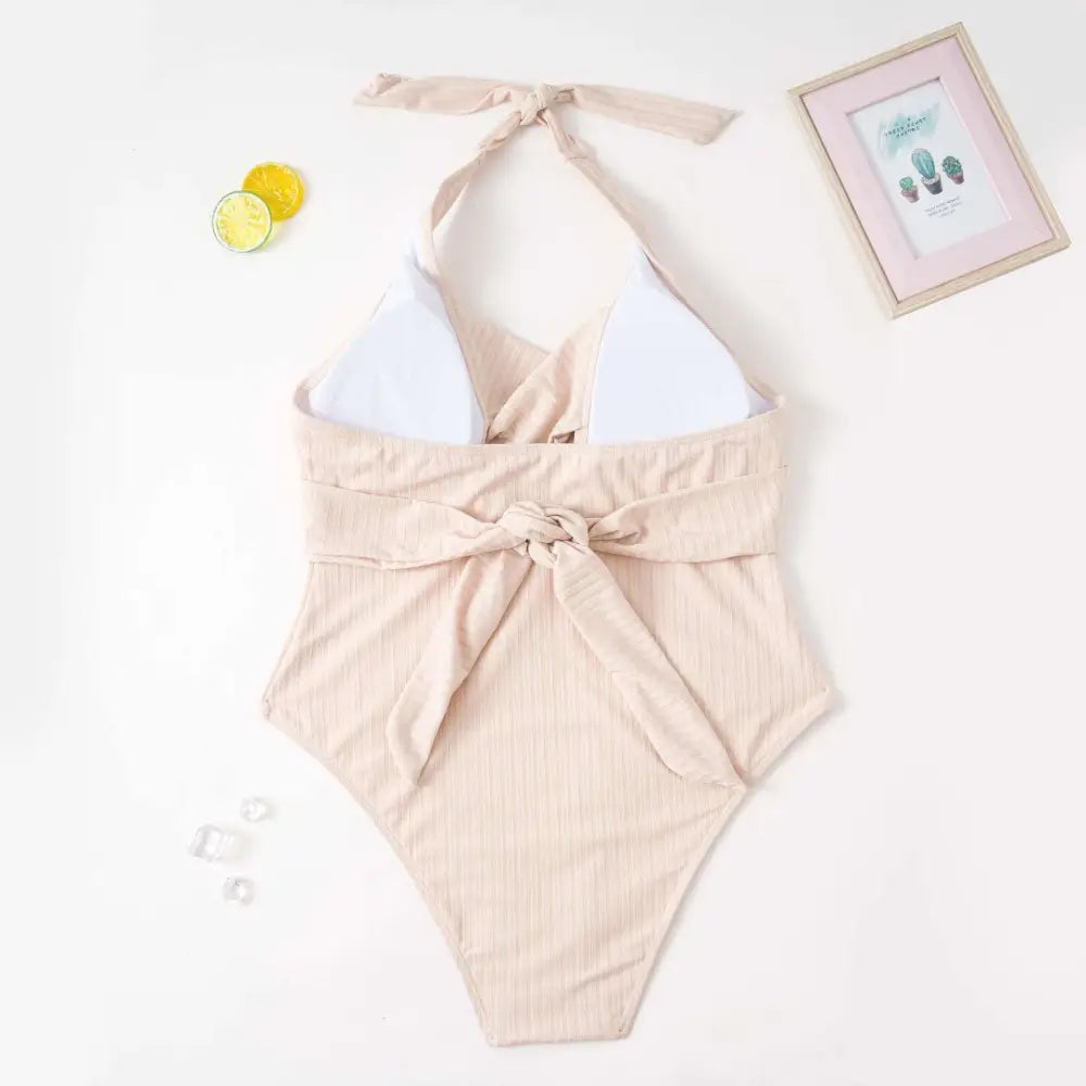 Beige ribbed one-piece swimsuit with white triangle halter neck top and tied waist in plus size fashion style