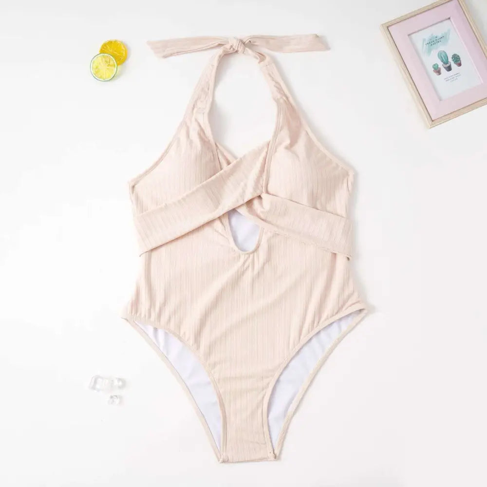Beige ribbed one-piece swimsuit with halter neck, front cross straps, and keyhole cutout for plus size fashion