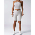 White high-waisted bike shorts with side pockets and sleek design paired with beige ribbed high waist workout set
