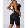 Black form-fitting high waist workout shorts with side pocket paired with beige ribbed high waist workout set