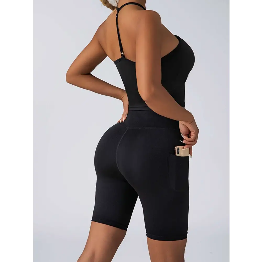Black form-fitting high waist workout shorts with side pocket paired with beige ribbed high waist workout set